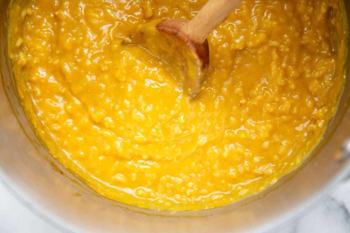 mixing pumpkin puree into the ingredients in the saucepan