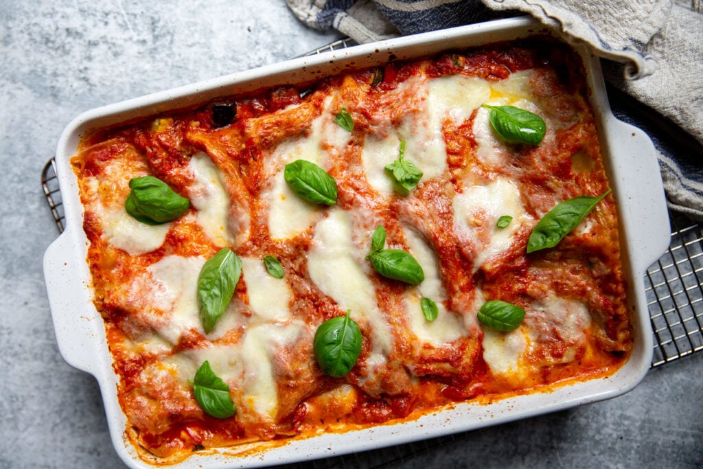 The top of the lasagna sprinkled with basil sprigs.
