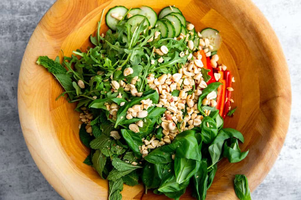 Vietnamese chicken salad ingredients in a wooden salad bowl before being combined.