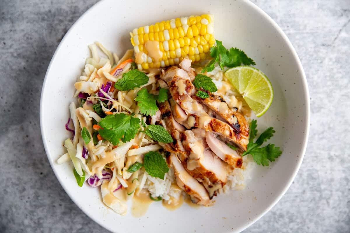 Grilled miso chicken in a rice bowl with white rice and veggies. 