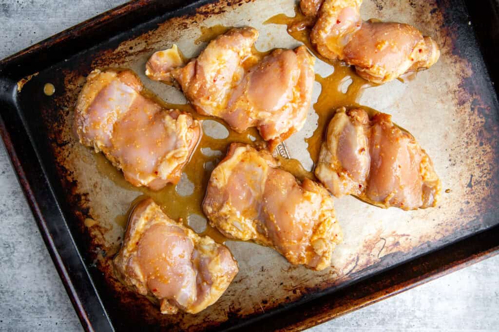 Raw, miso marinated chicken on a sheet pan. 