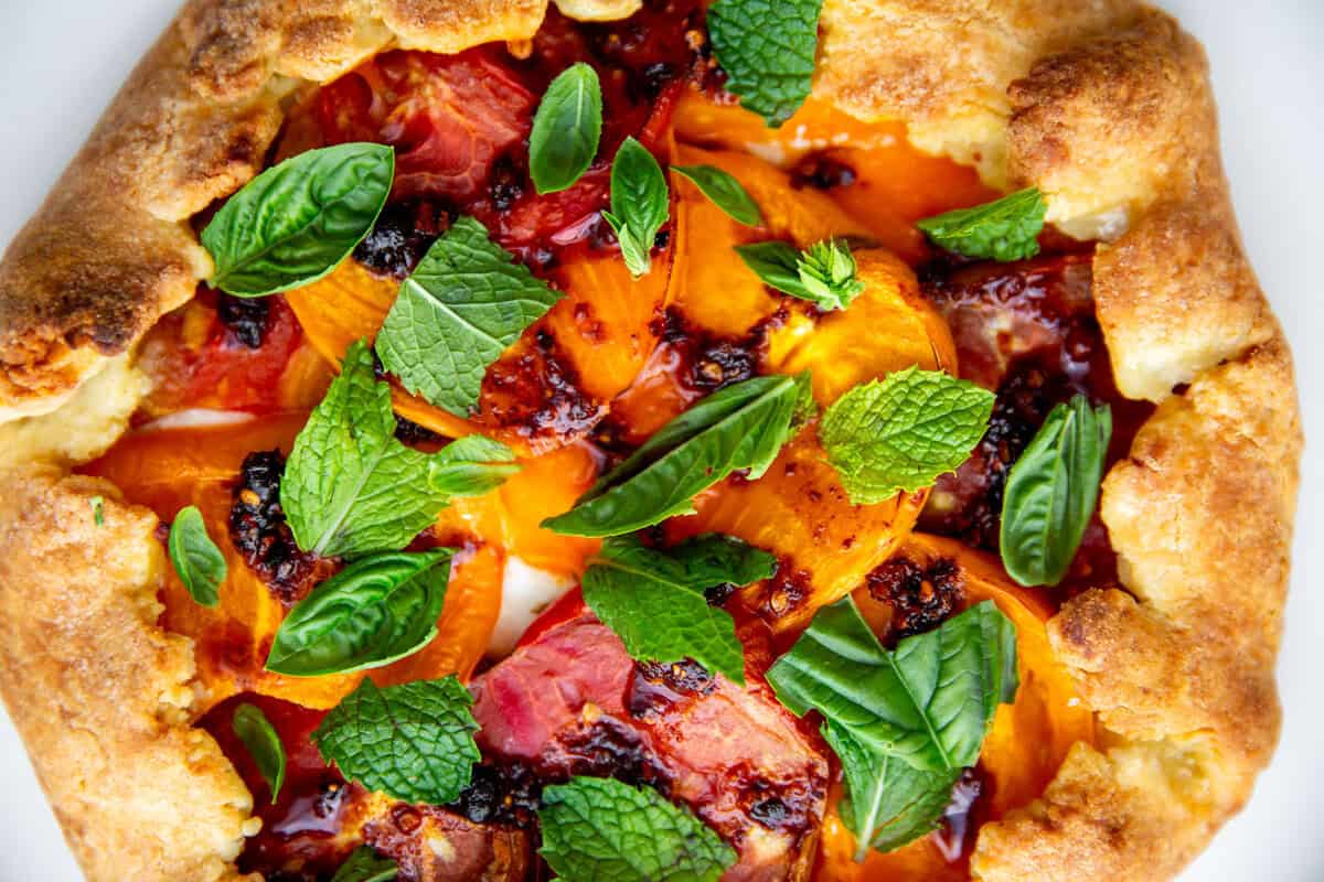 an up close photo of the tomato galette showing the fresh mint and chili crisp atop the tomatoes. 