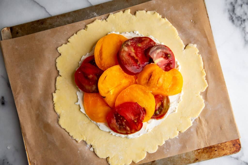 tomatoes spread on top of the pie dough and goat cheese. 