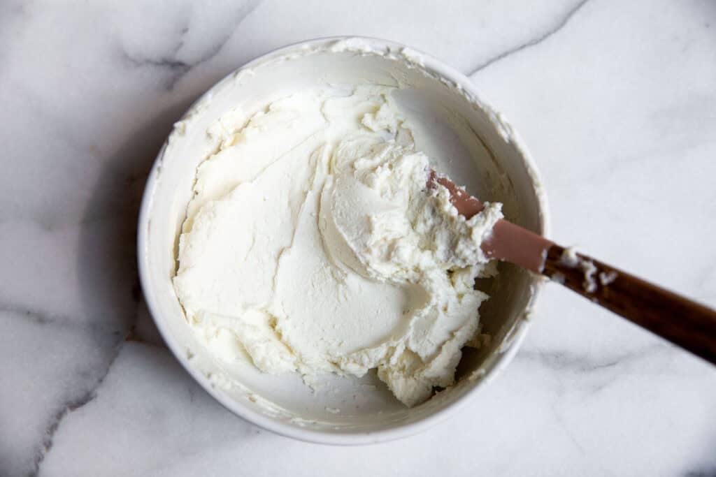 the goat cheese filling in a bowl with a spatula. 